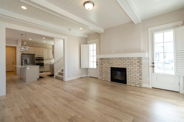 Bright and airy modern living space featuring a brick fireplace and open kitchen design.